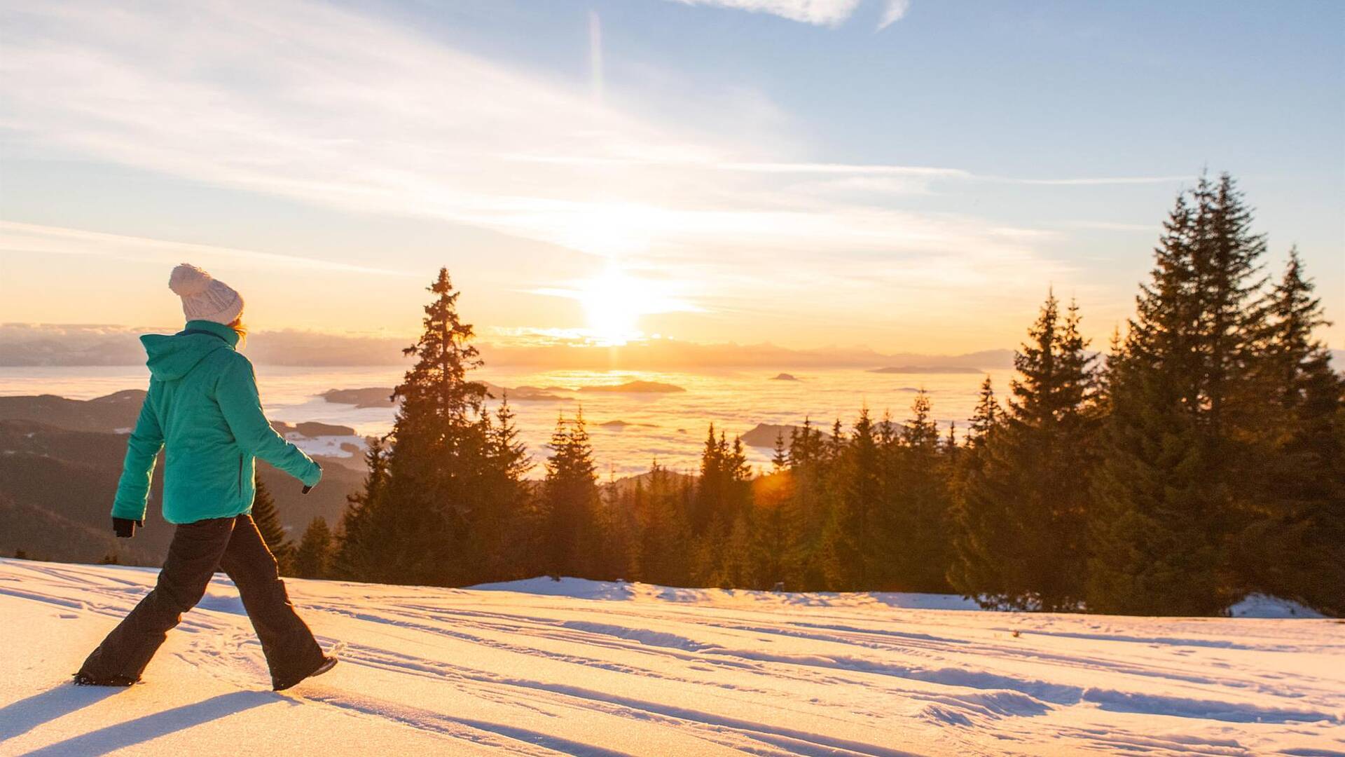 Frau im grünen Anorak beim Winterwandern auf der Saualpe